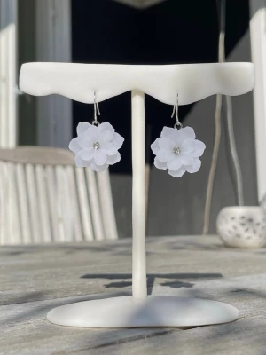 Handgjorda örhängen med vita blommor i polymerlera – Romantiska sommarsmycken (2,2 cm) - Handgjorda blomörhängen i polymerlera med mjuka, transparenta vita toner som fångar ljuset på ett elegant sätt. Varje blomma formas för hand med stor omsorg, vilket gör varje par unikt. Den lilla glittrande kristalldetaljen i mitten ger örhängena ett vackert skimmer. Lätta och bekväma att bära — perfekta till sommaren, för att ge vardagen en extra fin touch. •Handgjorda från grunden • Material: Fimo polymerlera (transparent vit) • FRI FRAKT! Storlek: ca 2,2 