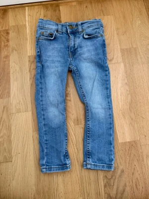Ljusblå jeans från Amy & Lucy - Snygga ljusblå jeans från Amy & Lucy i klassisk femficksmodell. Jeansen har raka ben, normal midja och slitningar för en trendig look. Perfekta till vardagsstilen och lätta att matcha med olika toppar.
