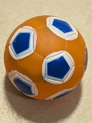 Orange och blå boll - En rund boll i orange med blå och vita femhörningar. Tillverkad i syntetmaterial och har klassiskt fotbollsmönster. Perfekt för lek eller träning inomhus eller utomhus. Liten plast boll