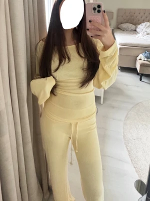 Gult loungewear-set med vida ärmar - Mysigt loungewear-set i ljusgul färg med långärmad topp och vida ärmar samt matchande byxor med dragsko i midjan. Mjukt och stretchigt material som passar perfekt för hemmamys eller chill dagar. Det är ”my chill” sett från Nelly! Har aldrig använt settet då jag inte tycker den passa mig! Både byxan och tröjan har fortfarande prislapp på vilket gör dem helt nya och oanvända!🫶