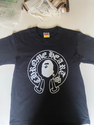 Bape Chrome Hearts - Svart Bape med Chrome Hearts. Helt nytt. Jätte bra kvalitet. Passar med storlek. Går med allt. Längd: 66cm. Bred: 49cm. Ärmar: 22cm. Aldrig använt den