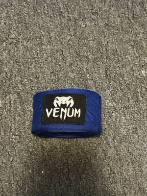 Blå boxningslindor från Venum - Säljer ett par blå boxningslindor från Venum med svart och vit logga framtill. Perfekta för träning inom boxning, MMA eller annan kampsport. Tillverkade i elastiskt material för bra stöd och komfort under passet.