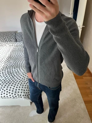 Grå stickad ziptröja - Säljer en stilren grå stickad tröja med dragkedja och krage från Massimo Dutti. Tröjan är i fint skick och är i storleken M! 😁✌🏼———————————————————————————                                                                          📐| Storlek: Medium                                                           👖| Märke: Massimo Dutti                                     🔎| Skick: Bra skick                                                ✍🏻| Skriv om du har några frågor