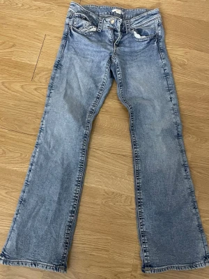 Ljusblå bootcut jeans med fickdetalj - Säljer ett par ljusblå bootcut jeans med cool fickdetalj framtill och bakfickorna. Jeansen passar folk med storlek xs och 158 kan även passa folk med S  Perfekt till skola/vardag/jobb fast ändå elegant. Perfekta för en avslappnad och trendig look.