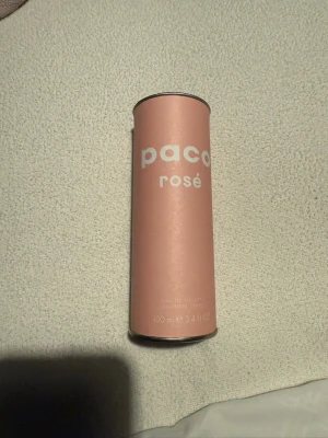 Paco Rosé Eau de Toilette 100 ml - Paco Rosé Eau de Toilette i en stilren cylinderformad flaska med ljusrosa färg och silverdetaljer. Flaskan rymmer 100 ml och har en modern, minimalistisk design som känns både trendig och elegant. Perfekt för dig som gillar fräscha och feminina dofter.