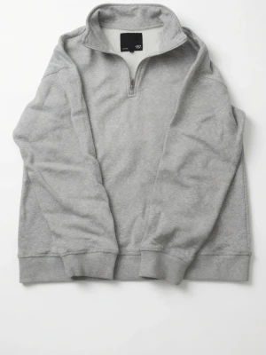 Grå halvzip hoodie från  - En stilren grå hoodie från 157 med halv dragkedja framtill och hög krage. Tillverkad i mjukt sweatshirtmaterial med ribbade muddar vid ärmar och nederkant. Perfekt för en avslappnad look och enkel att matcha med andra plagg.