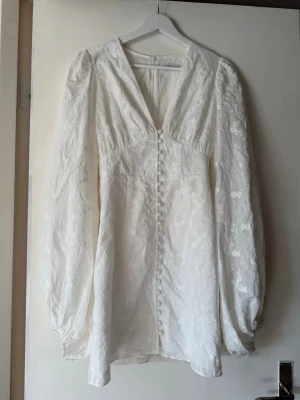 Vit adoore florence klänning - Har använts en gång, fint skick förutom den lilla fläcken på höger bröst, däremot inget som märks när den används. Jag är 150cm lång och klänningen går lite under knäna. Säljes p.ga att den inte passar något mer.