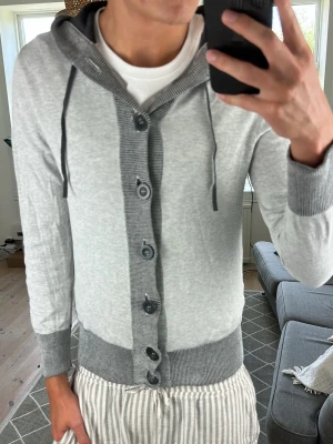 Stickad Cardigan/Hoodie grå - Unik och extremt snygg! Inga defekter. Mått: A:48 B:42 C:36 D:56 (cm) Skriv vid fundering!😇🙌