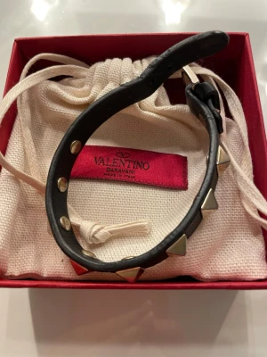 Valentino armband - Så så snyggt valentino garavani rockstud armband i svart med guld nitar.