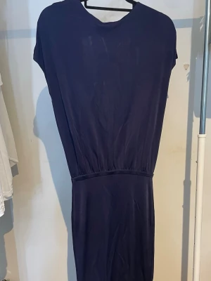Marinblå klänning  - En marinblå klänning med öppen rygg från H&M. Klänning sitter tajt nertill och löst upptill. Klänningen skulle passa XS/S.