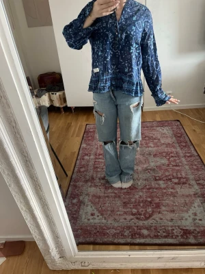 Blå mönstrad blus från Odd Molly - Snygg blå blus från Odd Molly med bohemiskt mönster i olika blå nyanser. Blusen har v-ringning, volangkant nedtill och långa ärmar med resår vid handlederna. Tillverkad i ett lätt och luftigt tyg som ger en avslappnad look. Pris kan diskuteras🩷