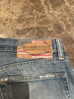 Denim and supply jeans - Jeans ifrån Denim and supply från Ralph Lauren, de är blåa o har få slitningar vid fickan o knät, storlek 29/32 ytterbensmått 101. Står slim men skulle säga mer regular. Skriv vid frågor
