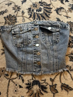 Jeans tubtopp med knappar och fickor - Säljer en snygg tubtopp från Shein. Jag har aldrig använt den pågrund av att den var väldigt liten i storleken. Storlek Xs men passar nog bäst Xxs💕