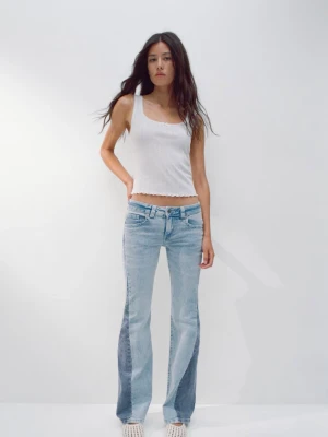 Unika low waist jeans from HM - Säljer ett par ljusblå jeans från H&Mmed cool utsvängd passform och kontrasterande mörkare paneler längs benen. Klassisk femficksmodell med dragkedja och knapp. Perfekta för dig som vill sticka ut med en unik denimlook. Jeansen är low waist och väldigt snygga på. Originalpris 349