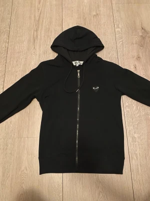Commes des Garçons zip hoodie  - Säljer nu min CDG zip hoodie då den är för liten,  använd några gånger och tvättad 1 gång. Helt nyskick (nästan), är priset för högt kom med ett bud, vid frågor eller liknande kontakta mig, vänlig hälsning!