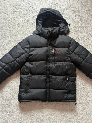 Svart jacka från Ralph luaren - Svart pufferjacka med huva från Polo Ralph Lauren. 🔥🔥 Storlek  M.  Passar även storlek S.       Hör av dig vid frågor och funderingar!!! 📲