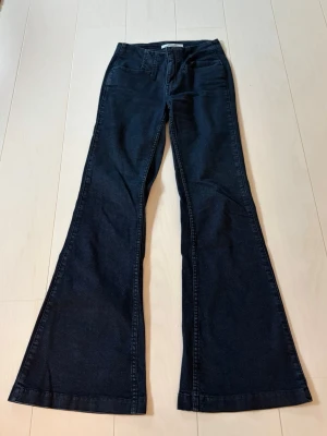 Mörkblå utsvängda jeans - Säljer ett par mörkblå jeans från bikbok med en väldigt fin passform. Ops det finns en liten defekt vid fram fickan 