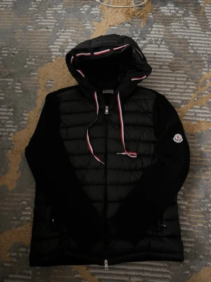 Moncler Cardigan - Säljer en fet o härlig cardigan som ingen pratar om, vill du stick ut från alla dom som använder klassiska cardigans o får dom o se ut som fakes, då rekommenderar jag den här cardigan med snören och en sjuk luva. Minst 2 komplimanger varje dag till ett sjuuuukt pris.