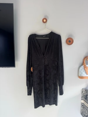 Svart klänning - Svart kortklänning från Gina Tricot med blommönster, väldigt stilren. Använd några gånger, kom privat för fler bilder eller frågor