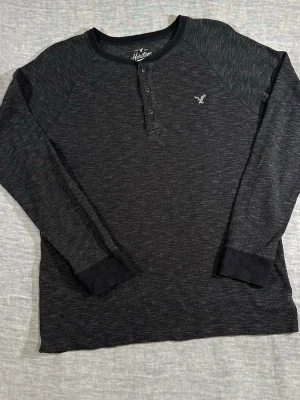American Eagle Thermal Waffle Knit Henley AEO Heritage Charcoal Size L - AEO heritage waffle knit thermal with 3-button henley. Clean everyday piece, nice texture and easy layering. Slight worn-in feel gives it that casual vibe.  Size L p2p 57 cm, length 73 cm, waist 55 cm raglan shoulder ~50–52 cm, sleeve 87 cm  good used condition
