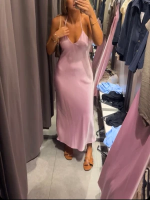 Ljusrosa långklänning med öppen rygg - Säljer denna jättefina ljusrosa långklänning i satin med öppen rygg. Använd ett fåtal gånger och är i väldigt bra skick. Skriv privat för fler bilder! Är i XS men är lite större i storlek så passar även S och M