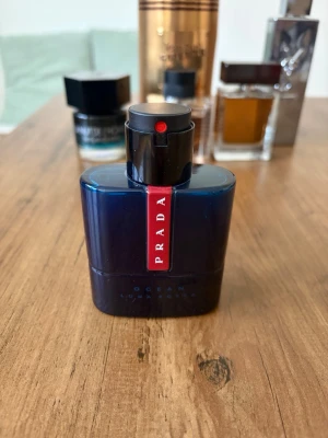 Prada Luna Rossa Ocean edt  - Prada Luna Rossa Ocean är en parfym i en snygg, mörkblå glasflaska med en röd vertikal etikett där det står PRADA. Flaskan har en modern och stilren design med svart spraymunstycke. Perfekt för dig som gillar exklusiva dofter och vill ha något som sticker ut.