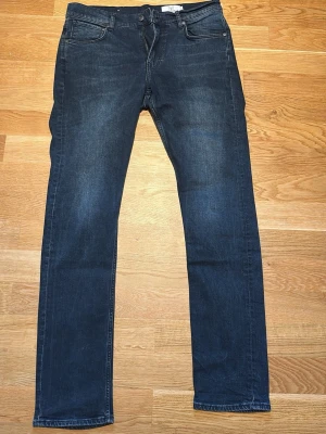 Mörkblå slim fit jeans - Snygga mörkblå slim fit jeans från Emilio (MQ).  klassisk femficksdesign och dragkedjegylf. Jeansen har en lätt tvättad look och raka ben. Perfekta för en stilren och avslappnad outfit. Strl 33/32