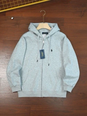 Grå hoodie från Polo Ralph Lauren - Snygg ljusgrå hoodie med dragkedja från Polo Ralph Lauren. Klassisk design med huva och justerbara snören, ribbade muddar och fickor framtill. Liten broderad logga på bröstet. Tillverkad i mjukt bomullsmaterial för skön känsla.
