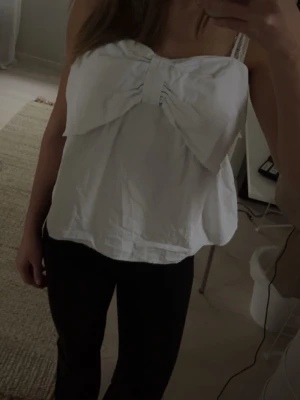 Vit bandeau tubtopp med rosett - Säljer en vit bandeau tubtopp med stor rosettdetalj framtill. 💗