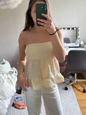 Beige bandeau tubtopp i bomull - Söt gul bandeau tubtopp i luftig bomull med volang nertill. 