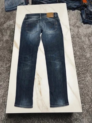 Schyssta dondup jeans - Snygga mörkblå jeans med raka ben och diskreta slitningar framtill och baktill. Klassisk femficksmodell med kontrastsömmar och läderpatch bak i midjan. Jeansen har en tvättad look och är tillverkade i denim, perfekt för en avslappnad stil. Storlek ungefär 29-30W 32L