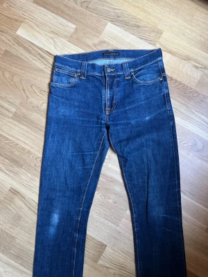 Nudie Jeans - Storlek W32 - Klassiska Nudie jeans raw-denim för män.  Storlek Waist 32 / Lenght 36. Nyskick, inga skador/slitage. Hör av dig vid intresse/frågor. PRIS KAN DISKUTERAS!