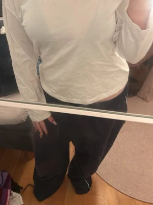 Vit långärmad topp i bomull - En enkel och stilren vit långärmad topp i mjuk bomull. Modellen har en normal passform och rund halsringning, perfekt att matcha med olika stilar. Passar dig som gillar basic och bekväma plagg. Pris kan alltid diskuteras