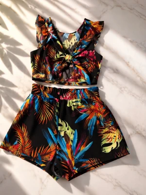 Färgglad croppad blus med knyt - Säljer en croppad blus med tropiskt blommönster i starka färger som blått, orange, gult och grönt på svart botten. Toppen har volangdetaljer vid axlarna och ett snyggt knyt framtill. Perfekt för sommarens alla äventyr!
