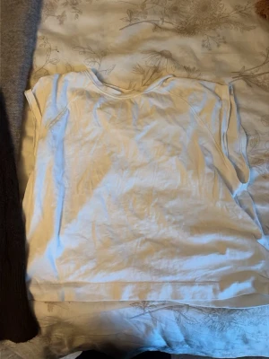 Vit ärmlös topp från Zara - En enkel och stilren vit topp från Zara. Modellen är ärmlös med rund halsringning och rak passform. Perfekt att matcha med jeans eller kjol för en clean look. Tillverkad i mjuk bomull som känns skön mot huden.