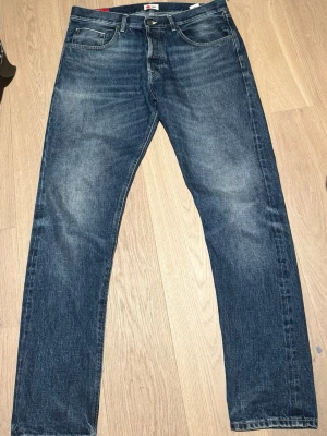 Blå raka jeans från Dondup - Klassiska blå jeans från Dondup med rak passform och fem fickor. Jeansen har en lätt tvättad look och är tillverkade i denim. Perfekta för en avslappnad stil och passar till det mesta.