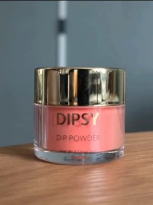 DIPSY Dip Powder persikorosa - Endast testad. DIPSY Dip Powder i en snygg persikorosa nyans. Kommer i en rund burk med guldig lock och transparent underdel. Perfekt för att skapa trendiga och hållbara naglar med en mjuk, matt finish.