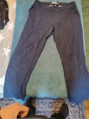 Mörkblå linnebyxor från Dressmann - Snygga mörkblå linnebyxor från Dressmann i storlek M. Byxorna har resår och dragsko i midjan för skön passform och är tillverkade i en linnemix. Perfekta för en avslappnad och stilren look. Nypris 600 och jag säljer för 300, det går att pruta 