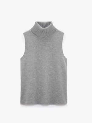 Grå ärmlös polotröja - Snygg grå ärmlös polotröja i mjukt stickat material. Tröjan har en hög ribbad krage och rak passform, perfekt att styla över en skjorta eller långärmad topp.