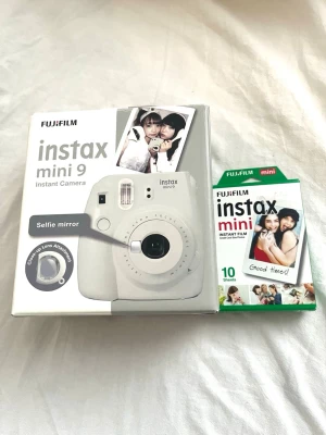 Fujifilm kamera - Fujifilm Instax Mini 9 i färgen Smoky White. Helt ny och aldrig använd. Kameran är en direktfilmskamera som skriver ut bilder direkt efter att de tagits. Den har en selfie-spegel och ett närbildsobjektiv. En oöppnad förpackning med 10 foton medföljer.