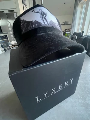 Svart keps ”Poseidon”  från Lyxery - Snygg svart keps ”Poseidon” i sammet från Lyxery by Sweden. Klassisk böjd skärm och mesh på sidorna för extra ventilation. Perfekt accessoar för en cool och avslappnad stil. Endast provad. Nypris 799 kr.