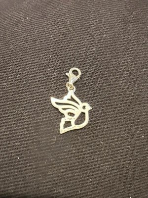 Thomas Sabo fågelberlock - Säljer en stilren berlock i form av en fågel, tillverkad i silver. Berlocken har en karbinhake som gör den enkel att fästa på armband, halsband eller väska. Perfekt för dig som gillar unika accessoarer med djurmotiv.