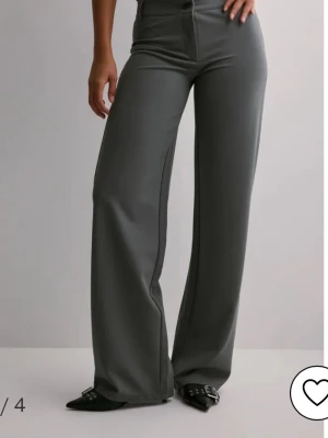 Gråa vida kostymbyxor - Grå kostymbyxor från Nelly, nästan aldrig använda. Storlek S men de når hela vägen till golvet på mig, och jag är 172 cm!