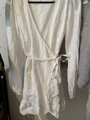Vit student klänning - Vit omlott klänning i linne material. den är i fint skick då jag använt den en gång. Skiv för fler bilder eller frågor