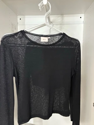 Svart transparent långärmad topp Nelly - Snygg svart transparent långärmad topp från Nelly. Tunn och lätt i materialet.