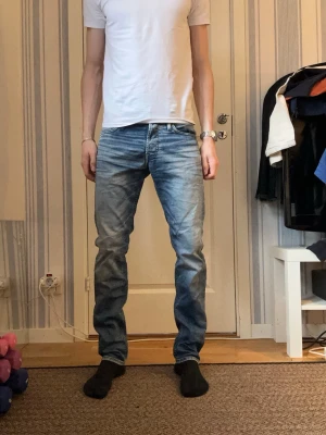 Slim fit jeans från Jack & Jones - Snygga ljusblå slim fit jeans från Jack & Jones, modell Glenn. Jeansen har klassisk femficksdesign, normal midja och dragkedjegylf. Tillverkade i stretchigt denim för extra komfort och en avslappnad look.
