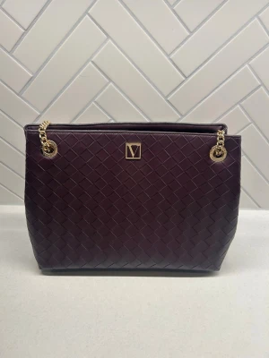 Black Violet handväska med guldkedja - The Victoria Shoulder Tote i färgen Black Violet (mörk lila). Orginellt köpte jag den för 1 200kr, jag har bara använt den 1 gång eftersom att jag föredrar mindre väskor. Den är som i nytt skick, inga missfärgningar och guldkedjan/ detaljerna ser mycket bra ut. Måtten är: 34,3 cm i längden, bredd 15,2 cm och höjden 26 cm💕
