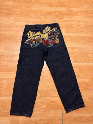 Mörkblå  jeans med brodyr - Säljer ett par mörkblå jeans från ninth hall. Köpt i en butik i usa. Bra skick inga skador