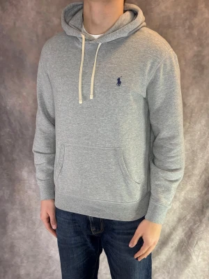 Grå Ralph Lauren Hoodie - Stl S - RIKTIGT FET RALPH LAUREN HOODIE! Mycket bra skick: 9/10, utan defekter! | Stl: S, Modellen är 175cm och väger ca 77kg | Rekommenderas att vara mellan 166-174cm lång för att sitta bäst! | Hör av dig vid frågor // Galgen 🫡