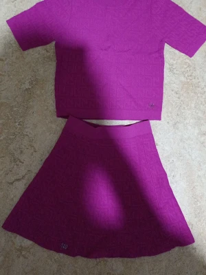 Lila topp från NN med strukturmönster - Alldrig används pga passar inte. Det är en tshirt med en tjol som är i skön material. Passar perfekt till olika tillfällen och är jättefin på. Hoppas den kommer till användning för den är jätte härlig och fin.